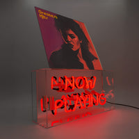 Neon sign with 'Now Playing' text with a vinyl record album cover on top with a gray background